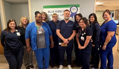 A group of nurses standing for a photo celebrating a fellow nurse